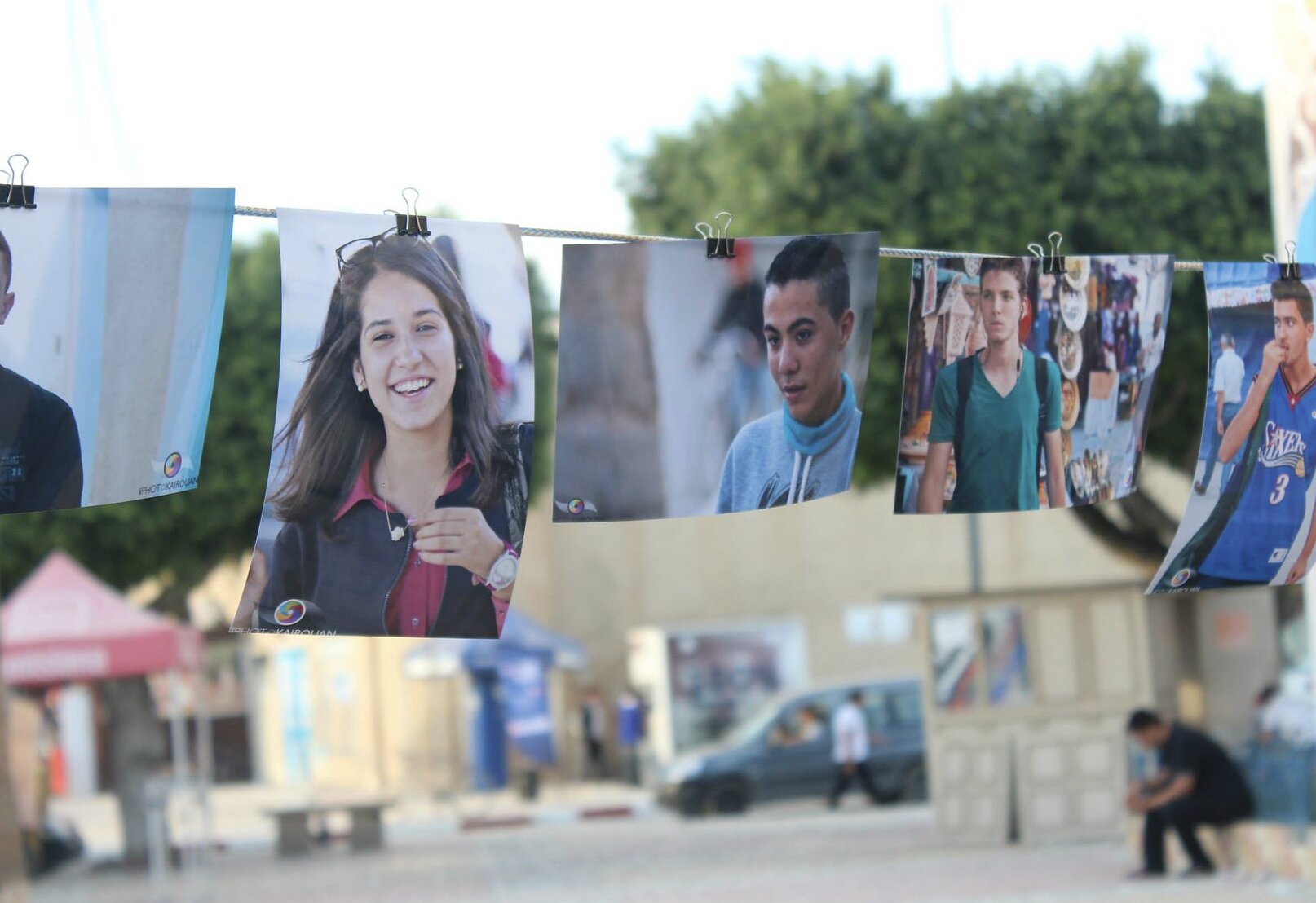 Portraits pegged to a line strung across the street in Kairouan