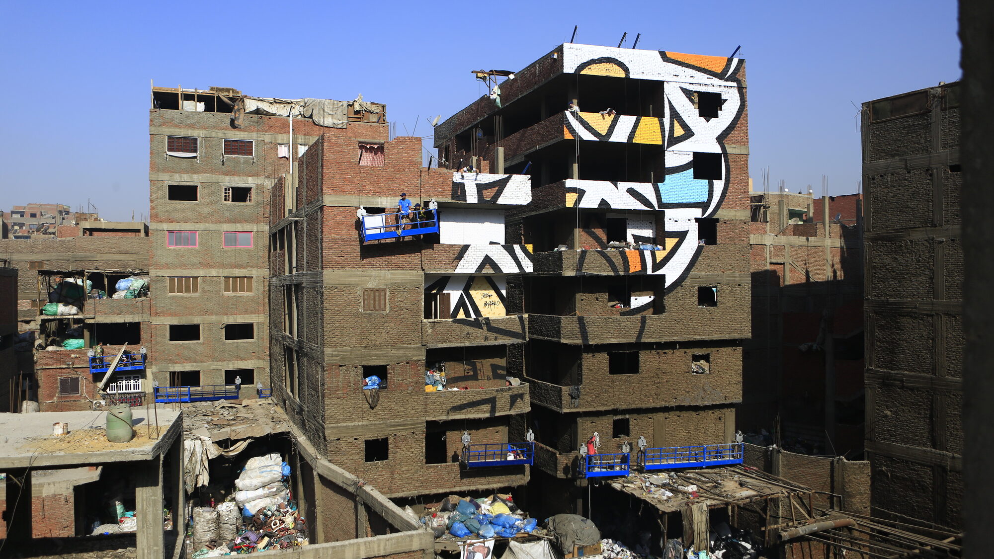 Early stage of painting the mural, workers on a lift